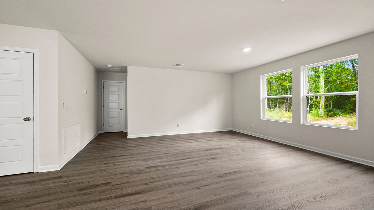 Open-concept living room with dual windows facing backyard