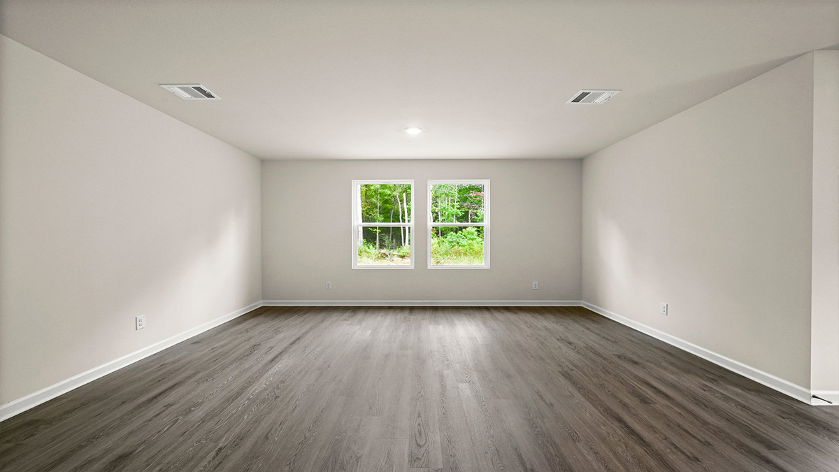 Open-concept living room with dual windows facing backyard