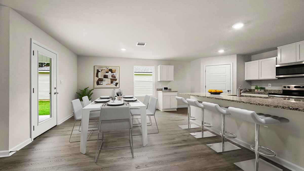 White kitchen island and open dining room with access to patio