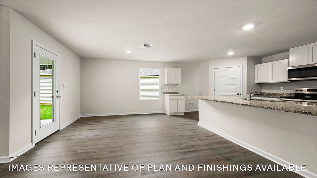 White kitchen island and open dining room with access to patio