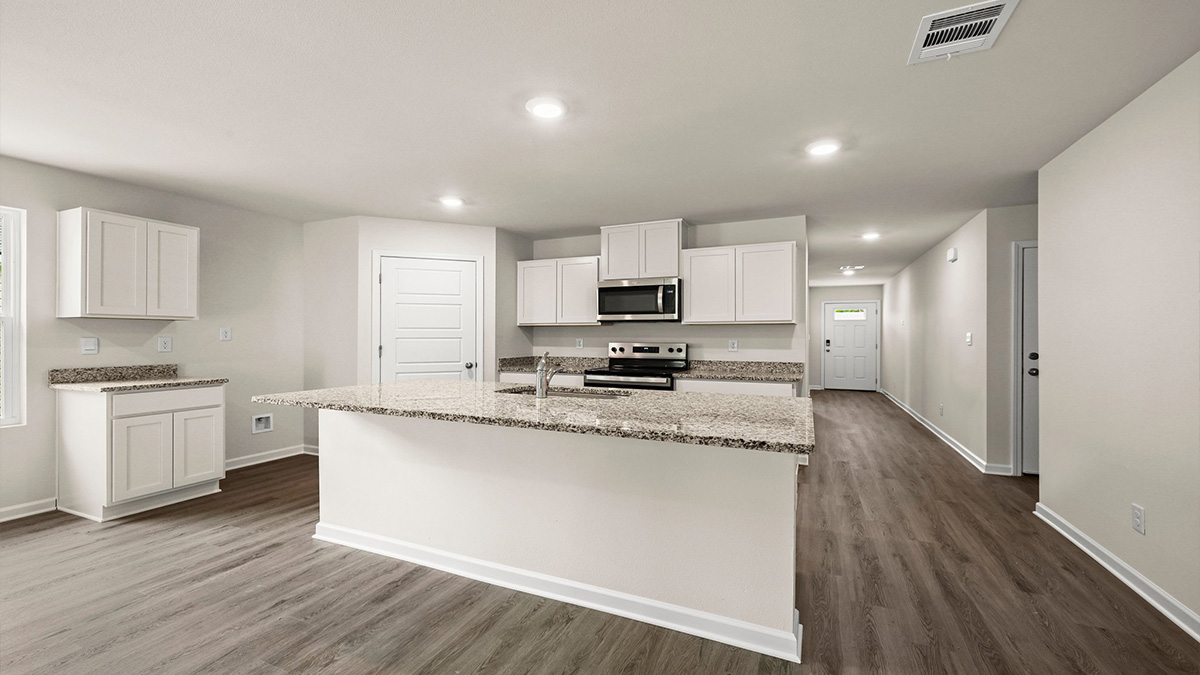 White kitchen island with stainless steel appliances with pantry access