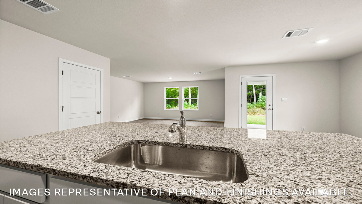 white kitchen island and gray granite overlooking the living space