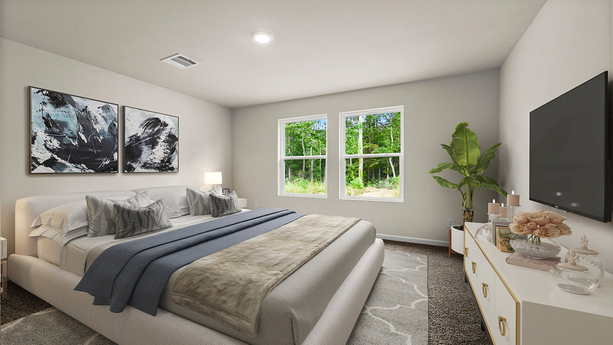 Large primary bedroom with dual windows overlooking the backyard