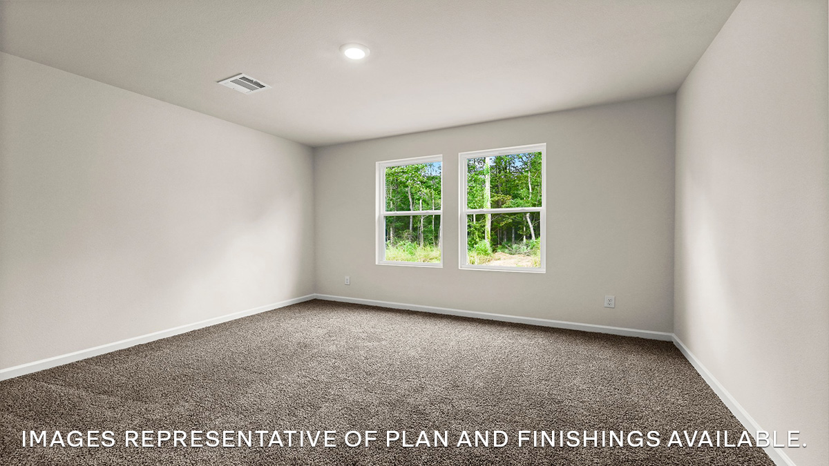 Large primary bedroom with dual windows overlooking the backyard