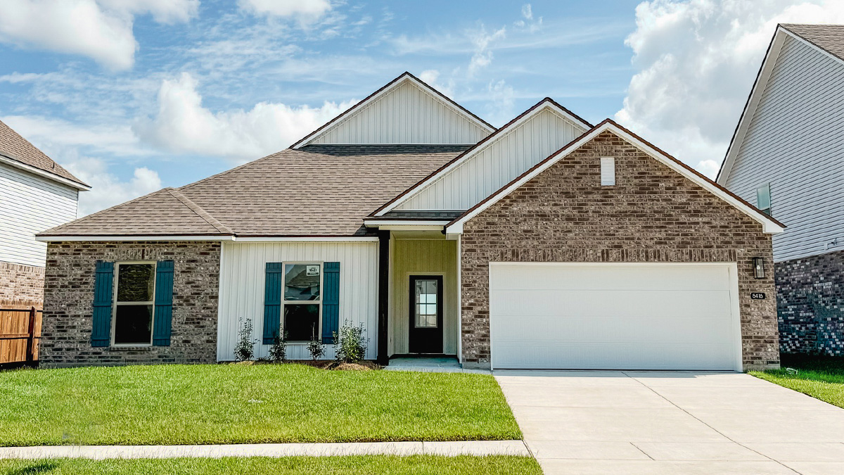 single-story home with tan brick with light gray vinyl siding and blue front door and shutters with two-car garage