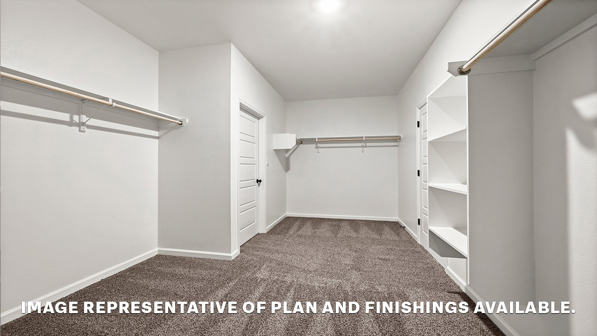 spacious walk in closet with dual shelving and racks with room for a shoe shelf