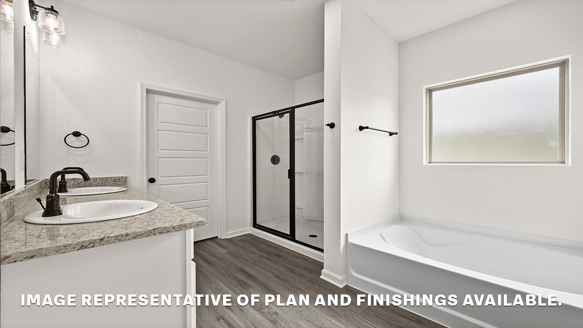 primary bathroom with dual vanity and separate tub and shower