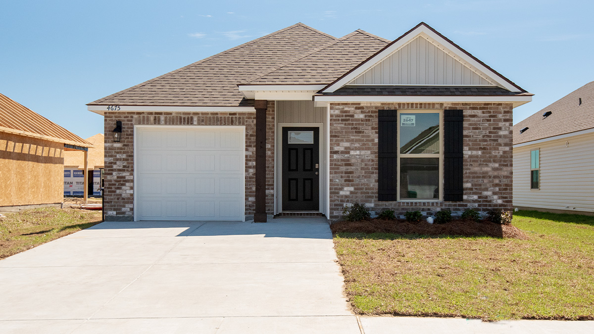 single-story home with grey brick and light gray vinyl with black front door and shutters with one-car garage
