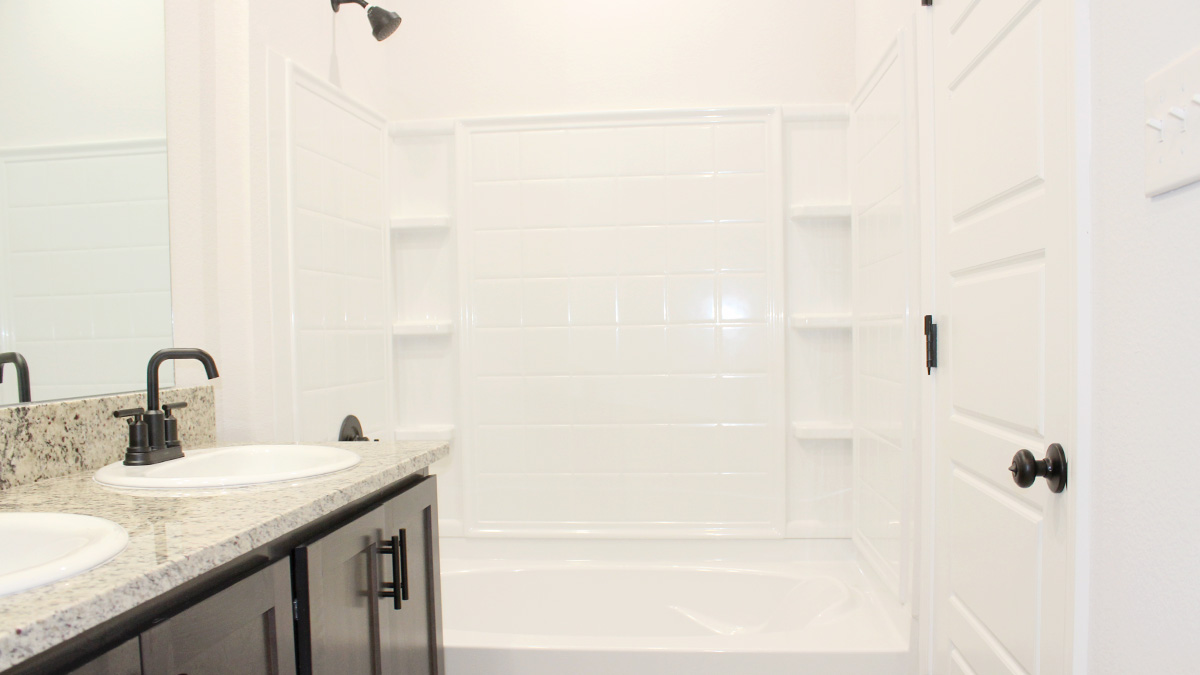 Dark dual vanities with shower and tub combo and toilet