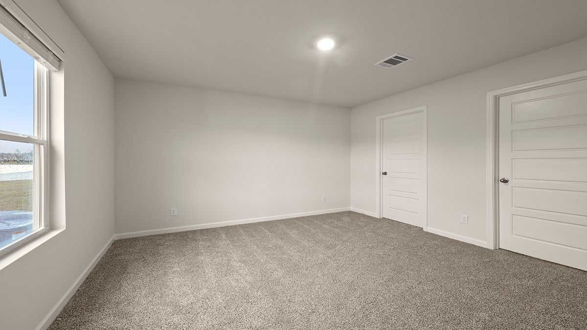 Primary bedroom with dual windows and opening to en suite and walk in closet