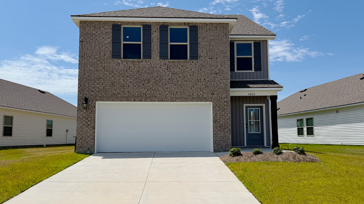 Two-story home with blue hardie vinyl and brown brick. Blue glass front door with blue shutters and white trim.