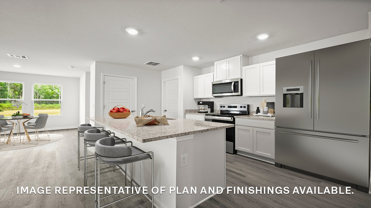 White kitchen island and open dining room with access to patio
