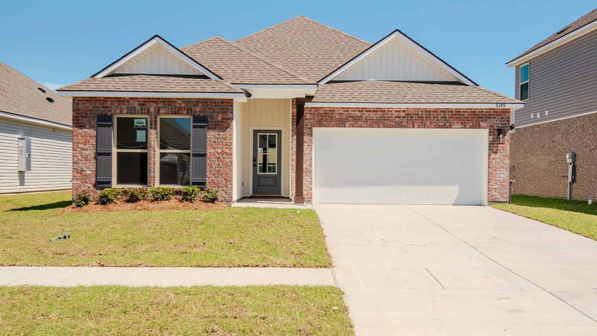 single-story home with red brick and white vinyl siding with gray front door and shutters with two-car garage