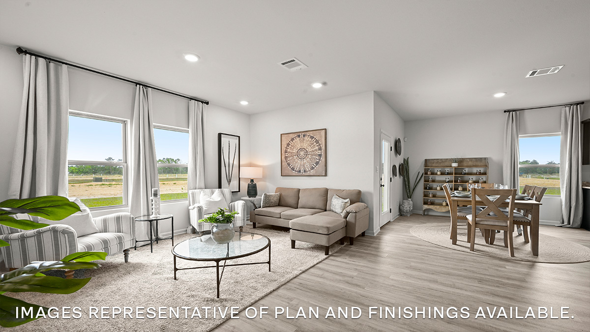 Open-concept living room with dual windows facing backyard