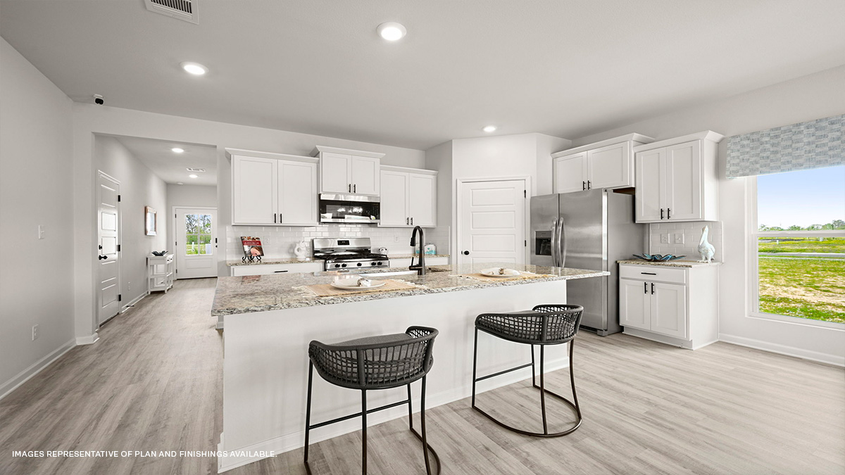 White kitchen island with stainless steel appliances with pantry access