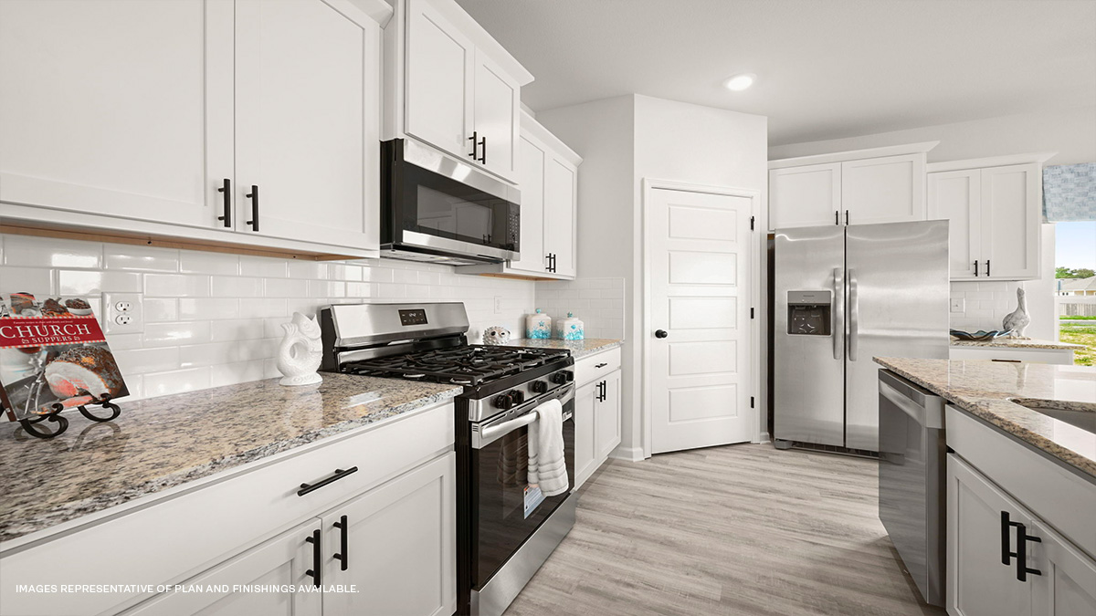White kitchen island with stainless steel appliances with pantry access
