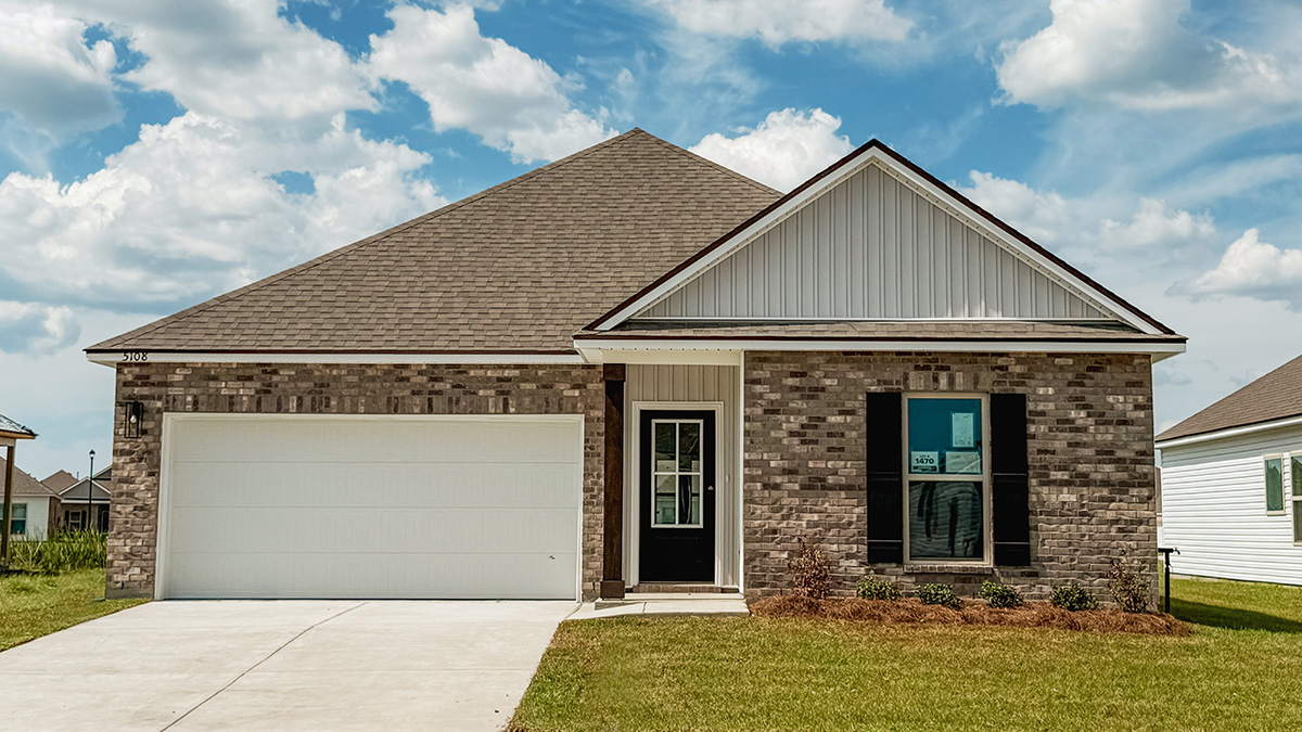single-story home with tan brick and light brown vinyl siding with black front door and shutters with two-car garage