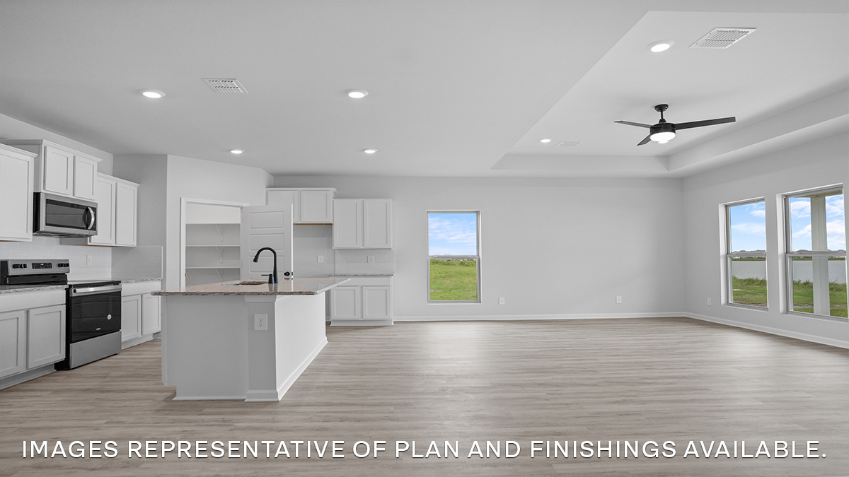 Open-concept kitchen with island and stainless steel appliances along with living room