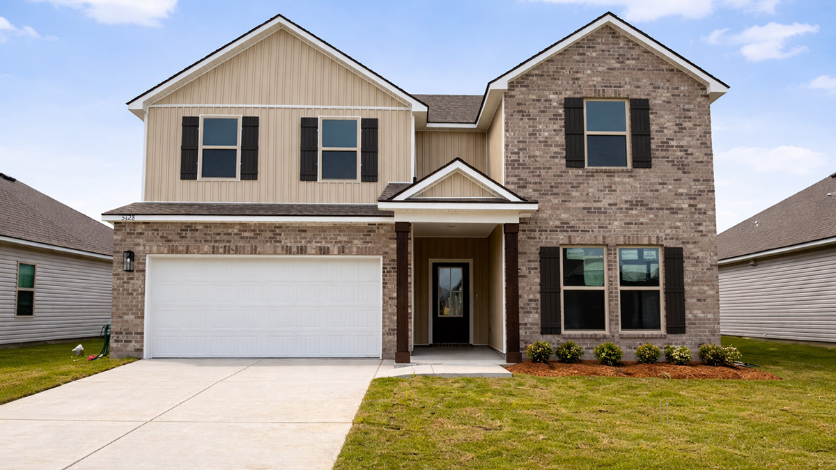 double-story home with brown brick and tan vinyl siding with two-car garage