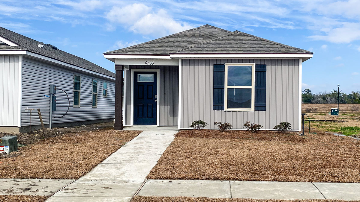 single-story home with gray vinyl siding and black front door and shutters