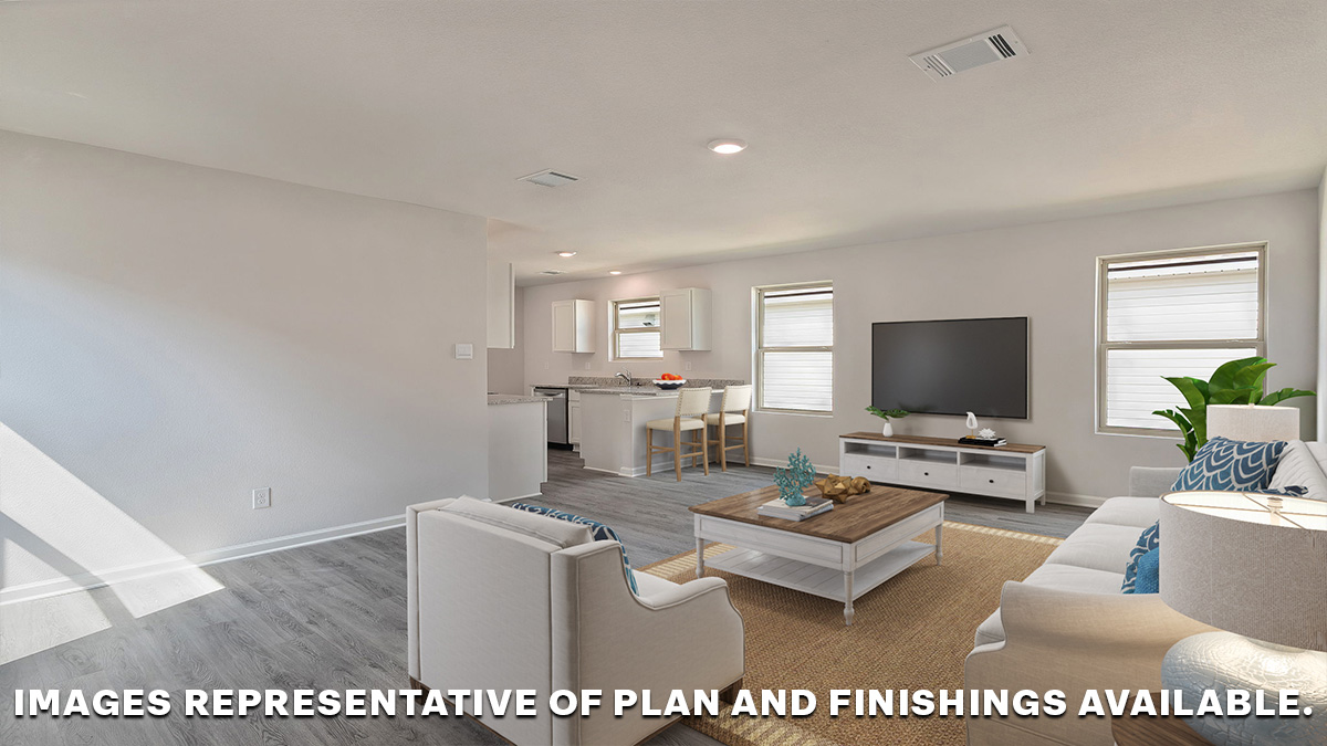 Open concept living space with dual windows looking into the yard with the kitchen nearby