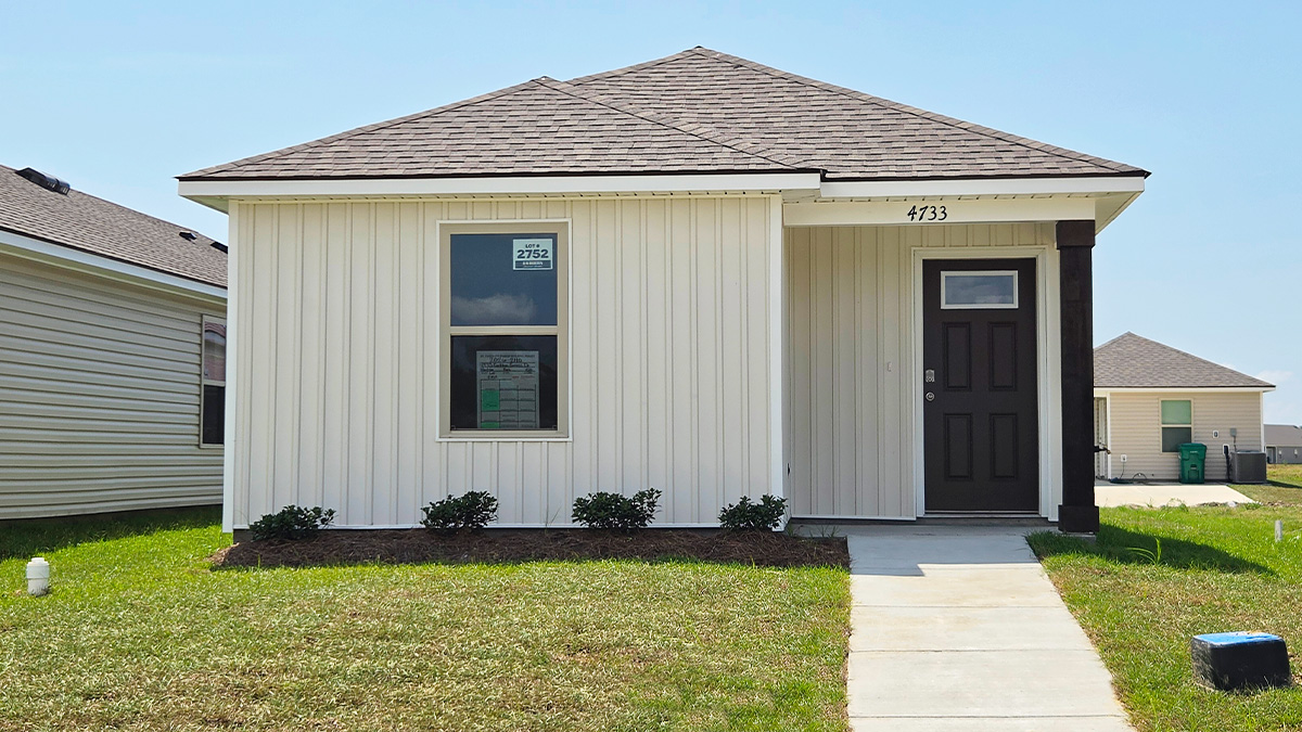 Single-story home with white vinyl. Black glass front door and white trim.