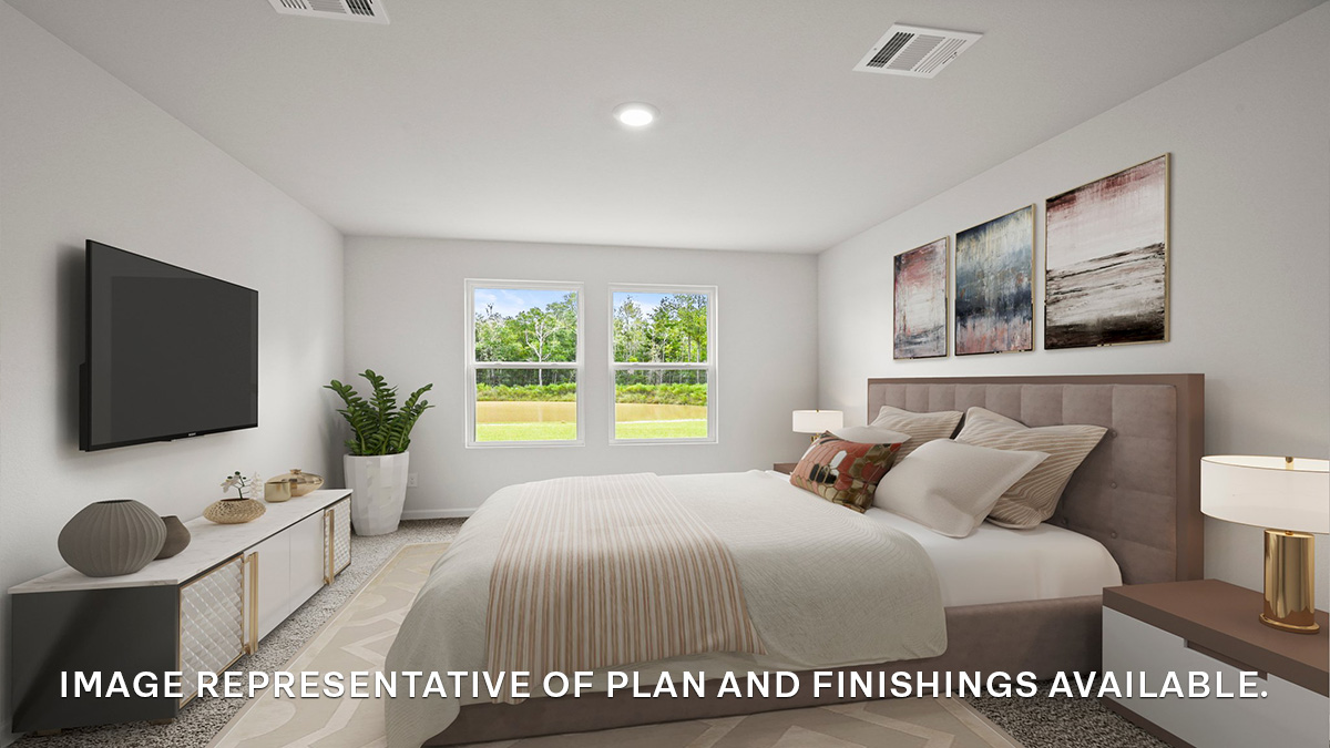 Large primary bedroom with dual windows overlooking the backyard