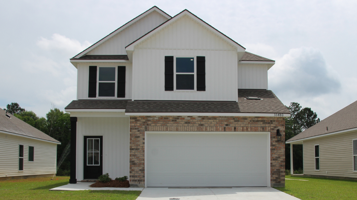 Two-story home with white hardie vinyl and brown brick. Black glass front door with black shutters and white trim.