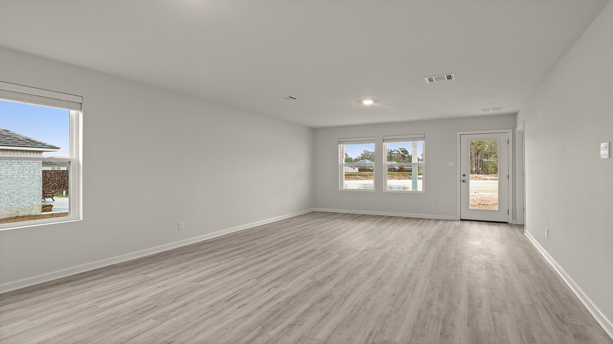 spacious living room with single side-view window with kitchen and dining space in the rear