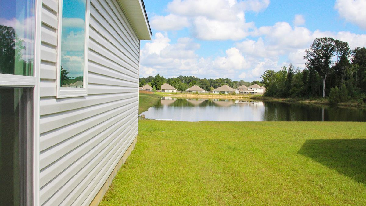 side yard with backyard view of pond