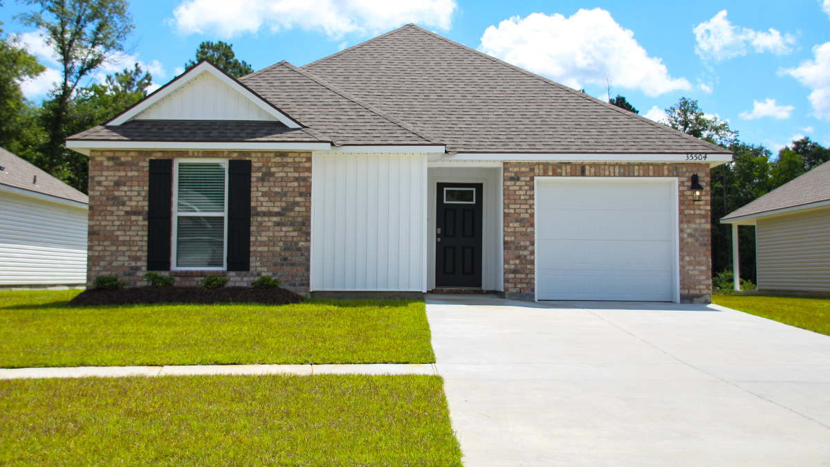 Single-story home with tan brick. Black glass front door with black shutters and white trim.