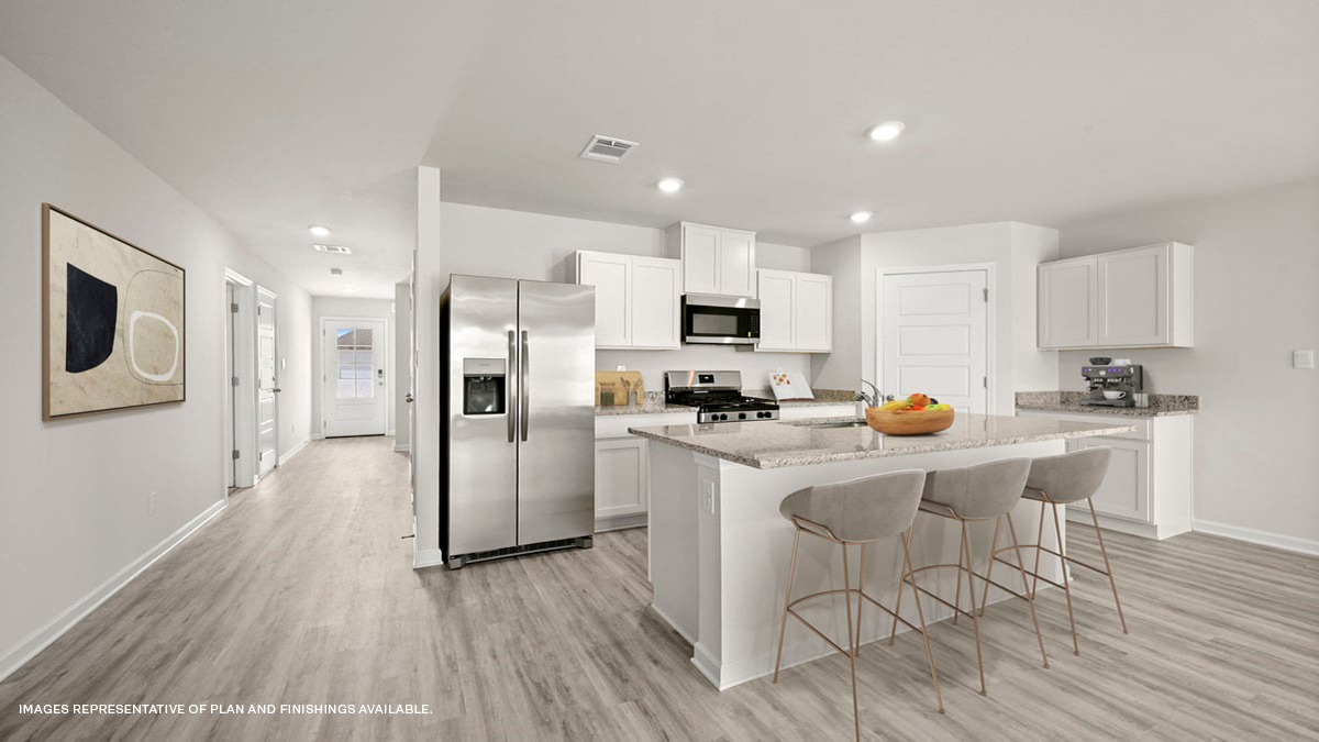 white kitchen island with stainless steel appliances and stools with access to pantry