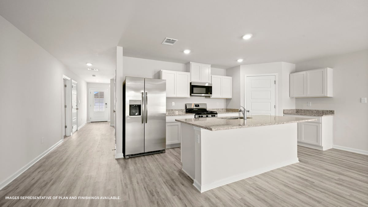 white kitchen island with stainless steel appliances and stools with access to pantry