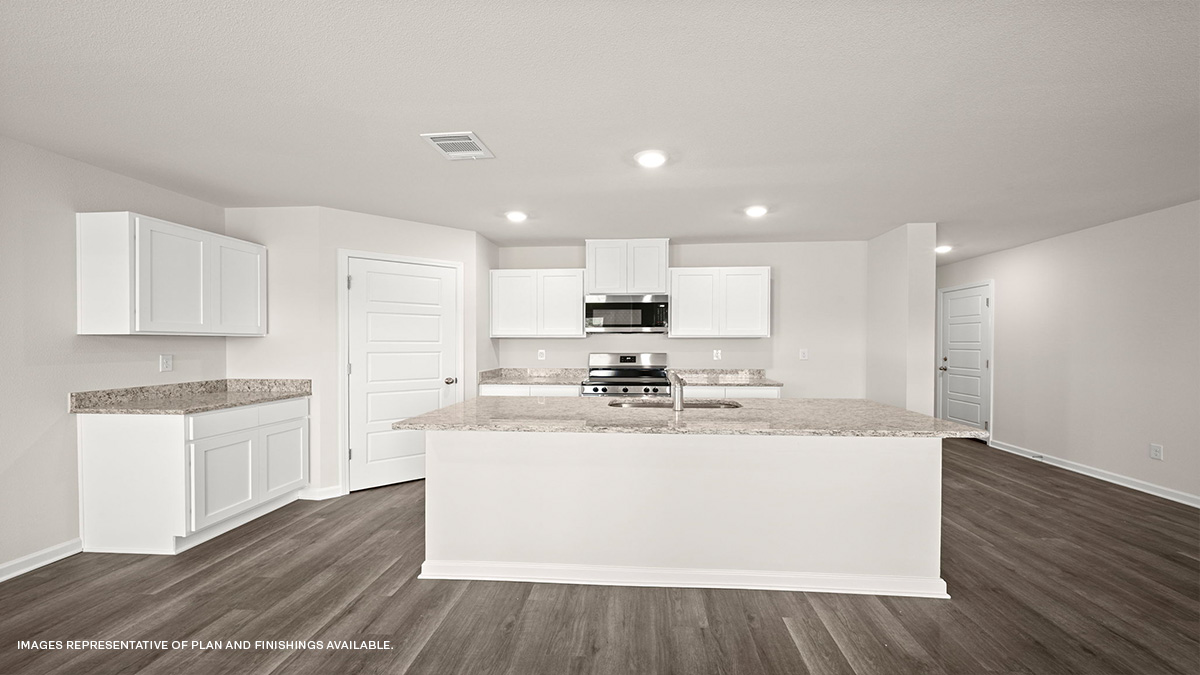 White kitchen island with stainless steel appliances with foyer and pantry