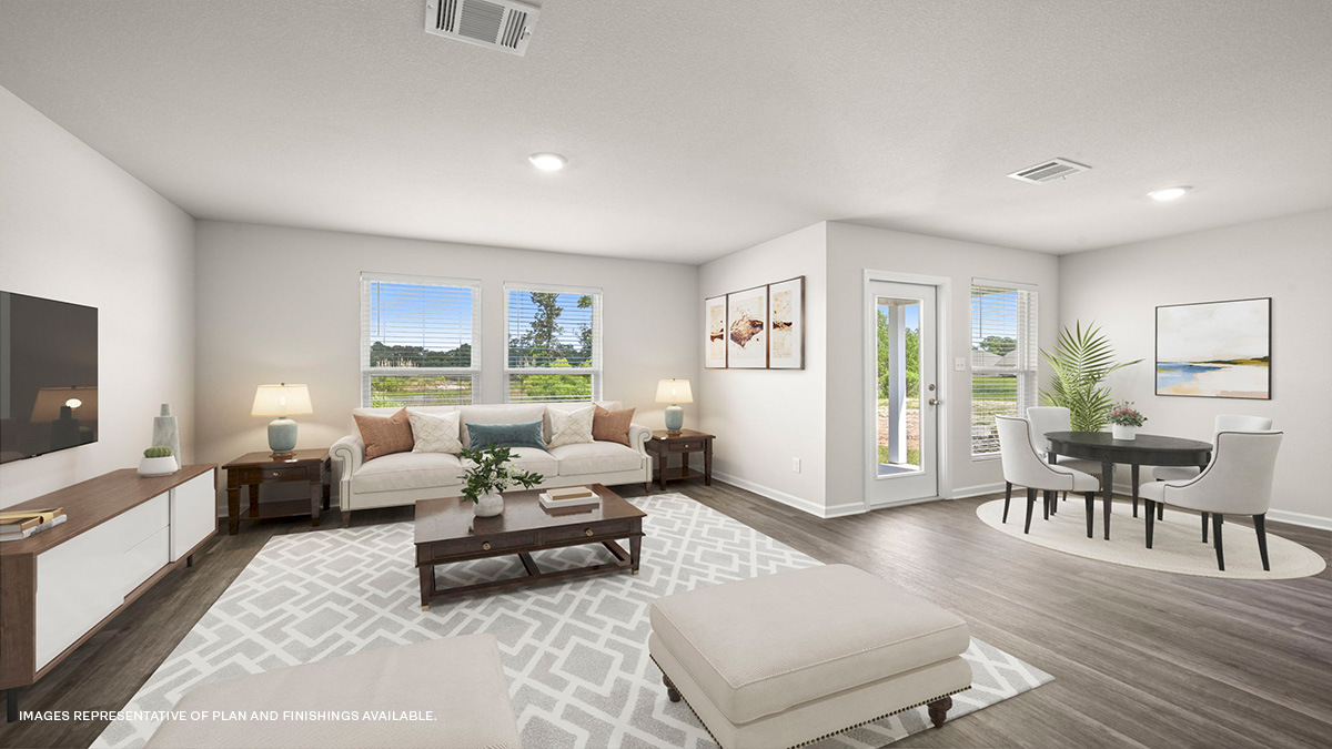 Open-concept living room with dual windows facing rear of home and dining space