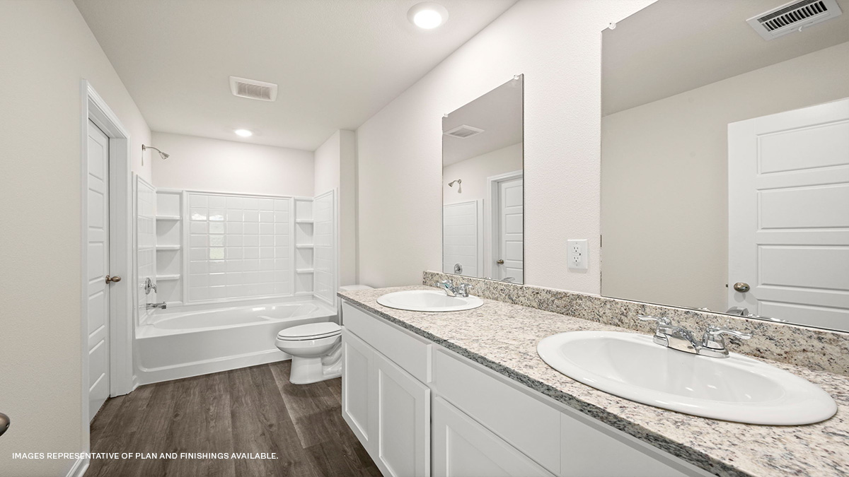 White dual vanities with shower and tub combo and toilet