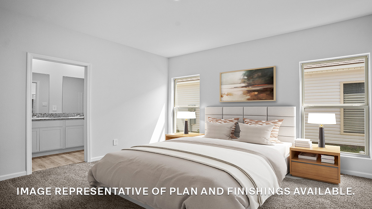 Large primary bedroom with dual windows overlooking the backyard