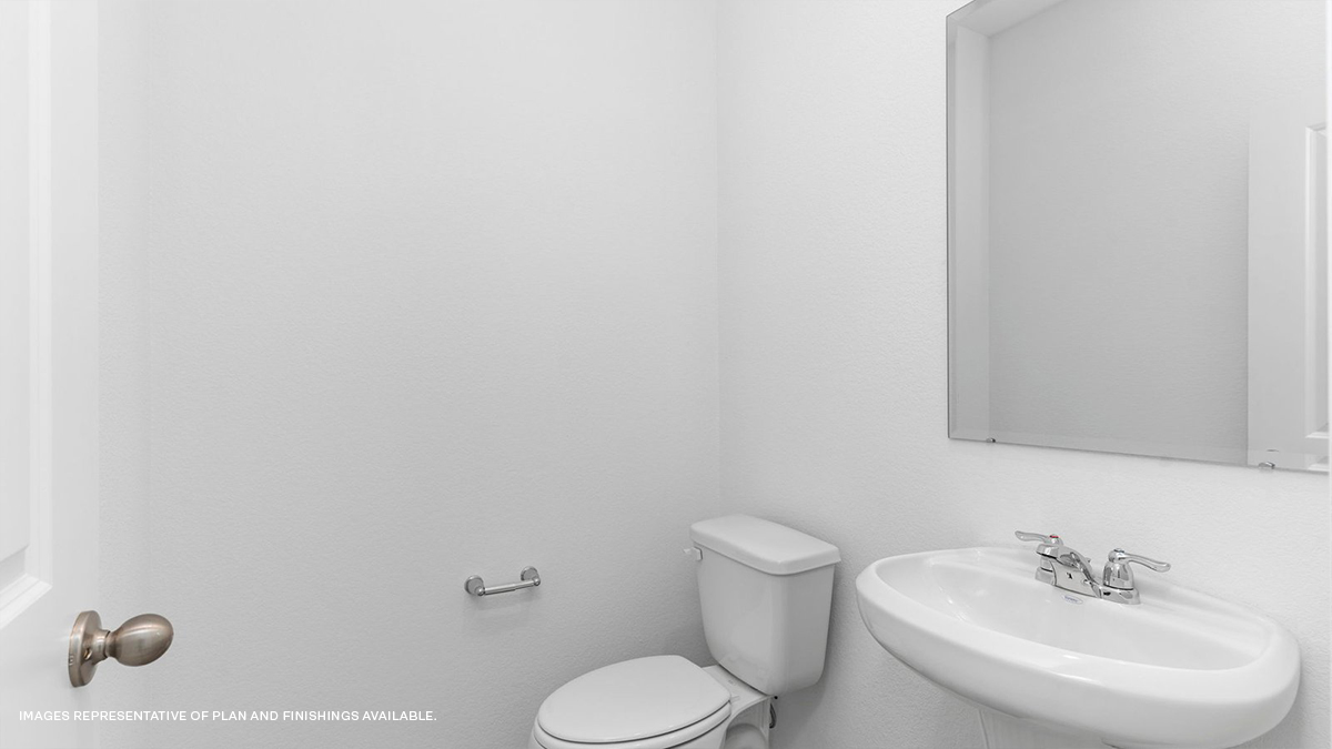 half bathroom in front of the home with pedestal sink and toilet