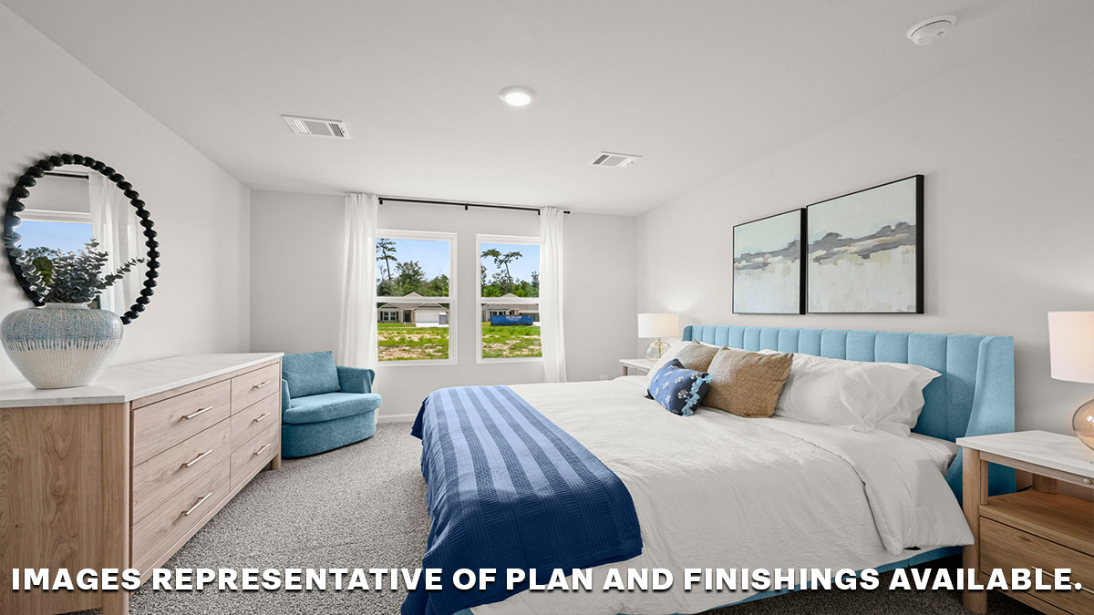 Large primary bedroom with dual windows overlooking the backyard