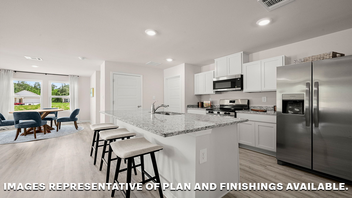 White kitchen island and open dining room with access to patio