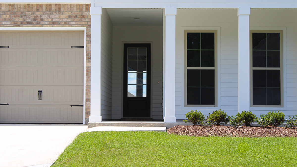 One Story Home with white vinyl tan brick and two car tan garage