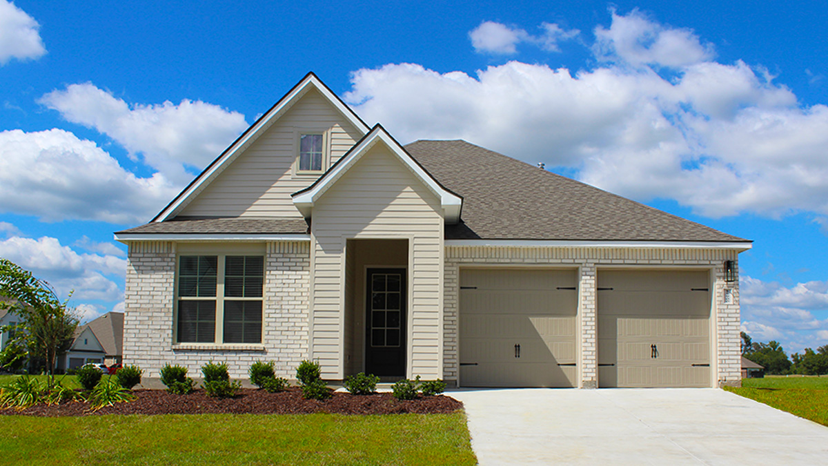 Single-story home with tan vinyl and brown brick. Black glass front door. and white trim.