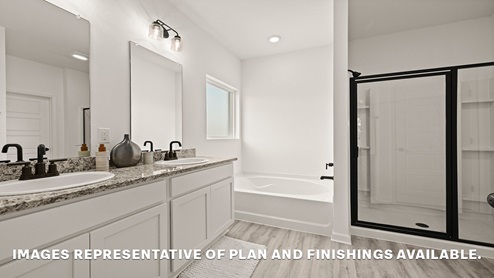 primary bathroom with dual vanities, mirror and separate shower and tub combo