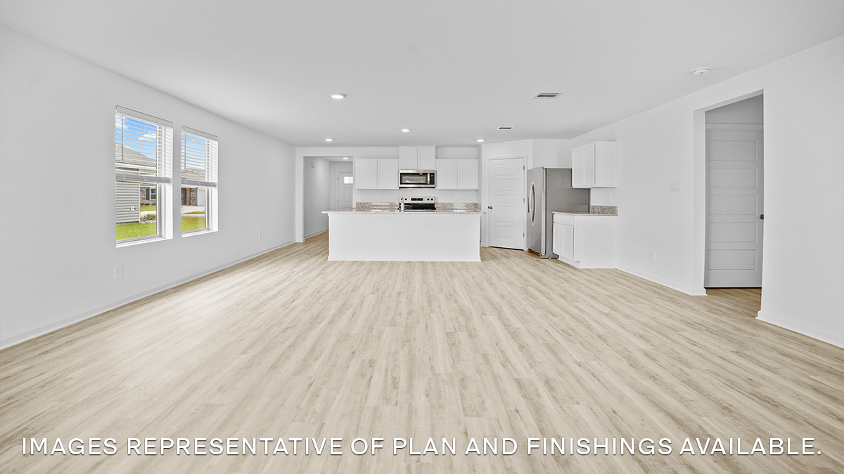 Open-concept living room with dual windows facing backyard and access to open kitchen