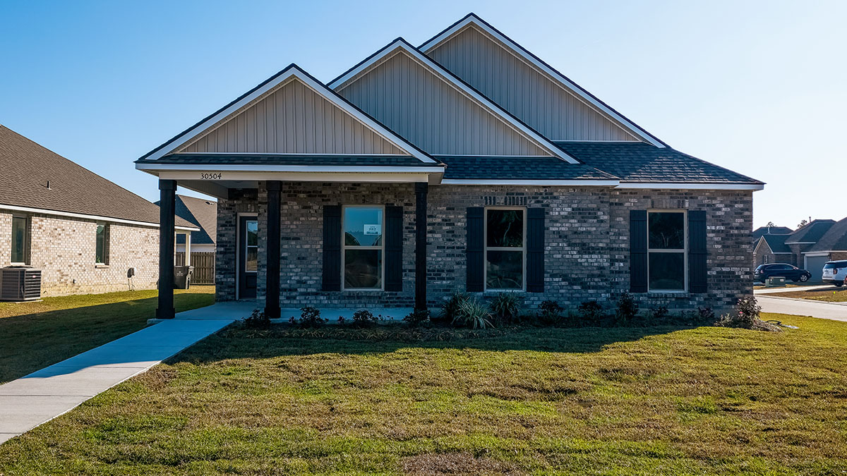 single-story home with grey brick and light gray vinyl siding with black front door and shutters