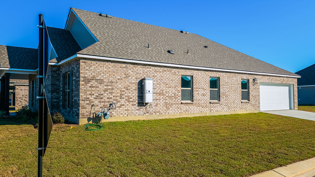 single-story home with grey brick and light gray vinyl siding with black shutters and two-car garage
