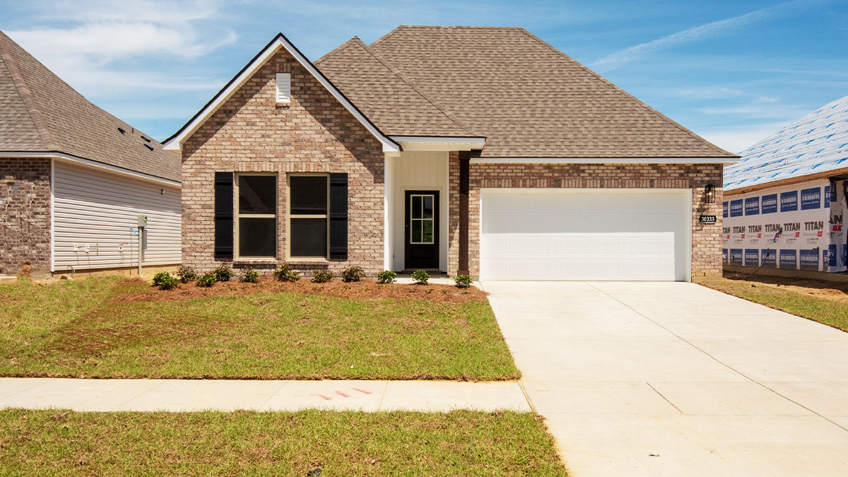 single-story home with brown brick and black front door and shutters with two-car garage
