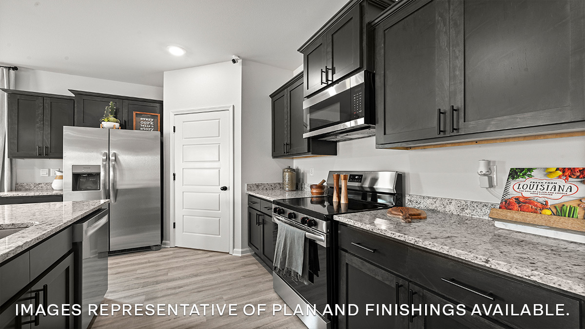 Dark kitchen island with stainless steel appliances and pantry access