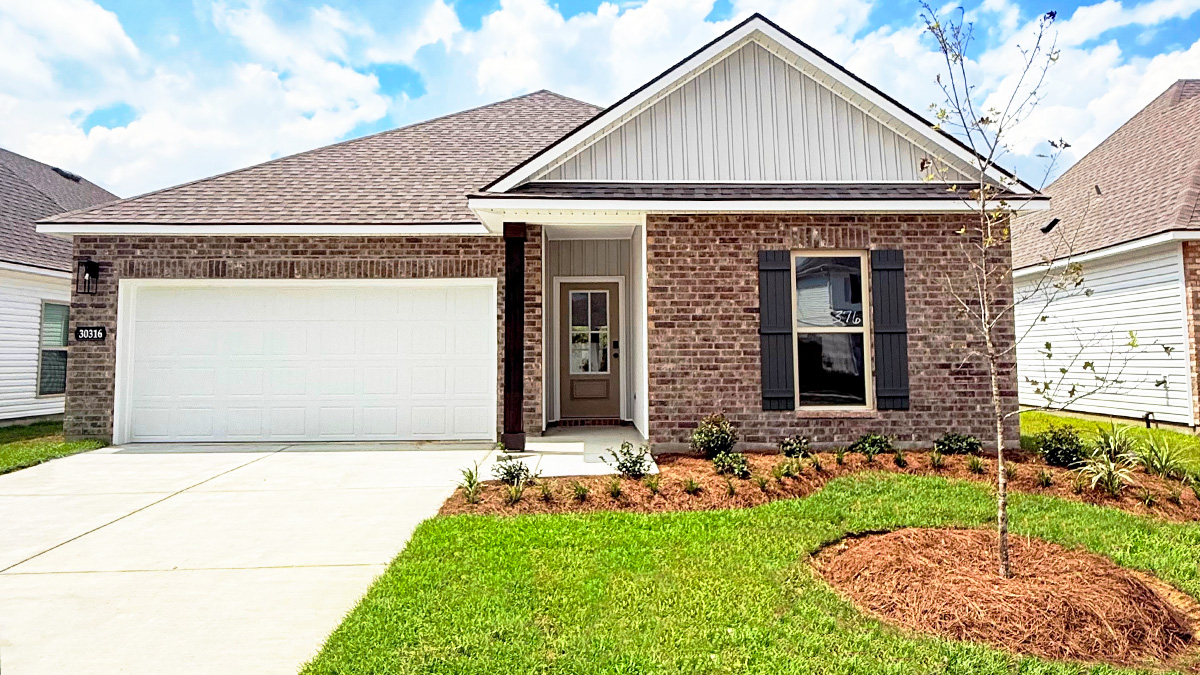 Single-story home with brown brick. Tan glass front door with dark grey shutters and white trim.