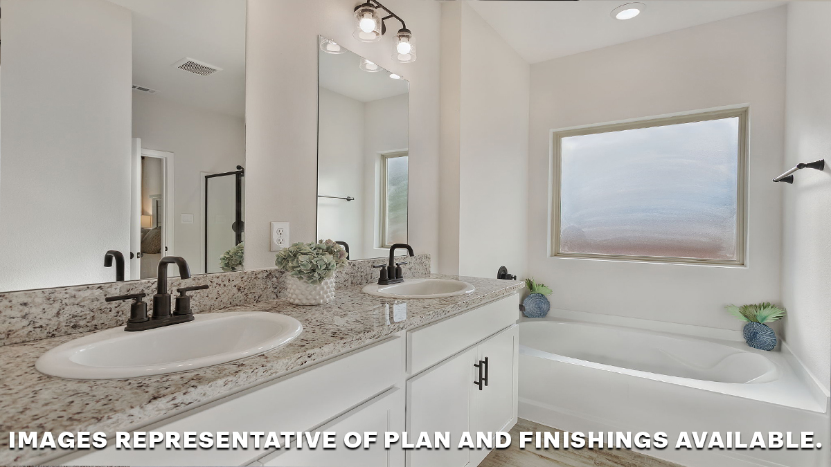 White dual vanities with garden tub in primary bathroom